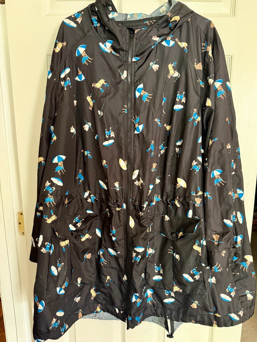 Woman Within Black Hooded Raincoat with Blue and Cream Umbrella Dog Print